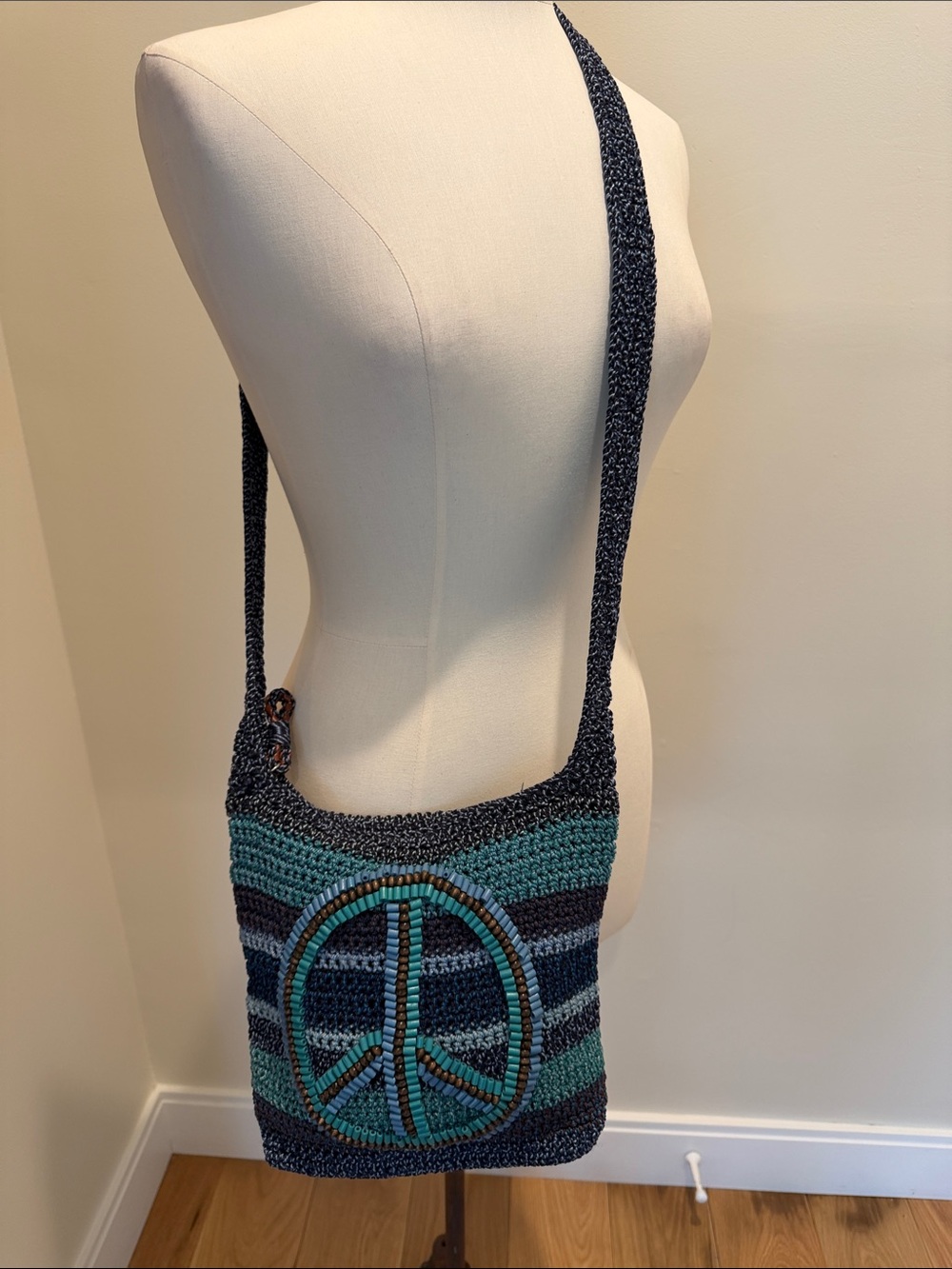 The Sak Teal and Navy Crochet Peace Sign Crossbody Bag with Wood Beads
